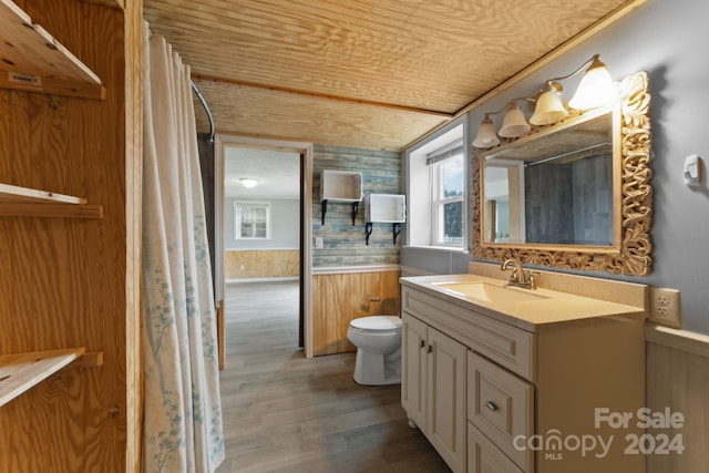 bathroom featuring toilet, wood walls, hardwood / wood-style flooring, wooden ceiling, and vanity with extensive cabinet space