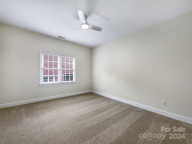 carpeted spare room featuring ceiling fan