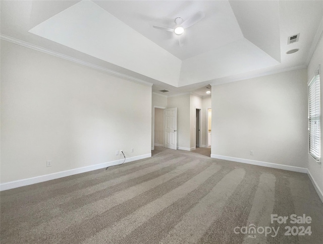 spare room with crown molding, ceiling fan, a tray ceiling, and carpet floors