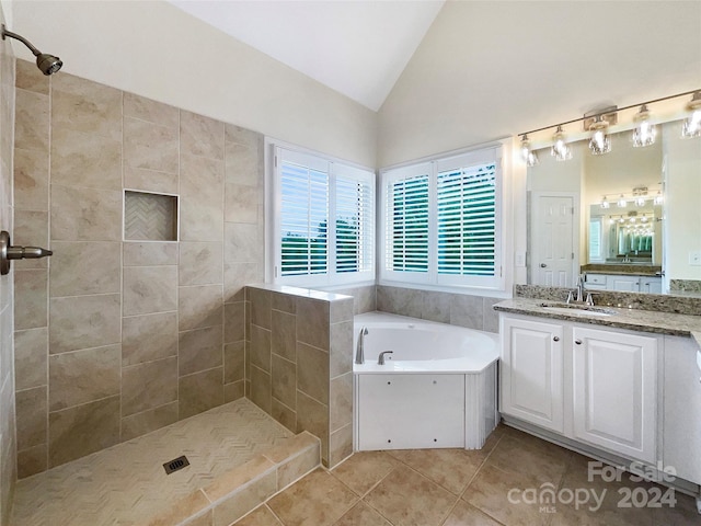 bathroom with independent shower and bath, vanity, lofted ceiling, and tile patterned floors