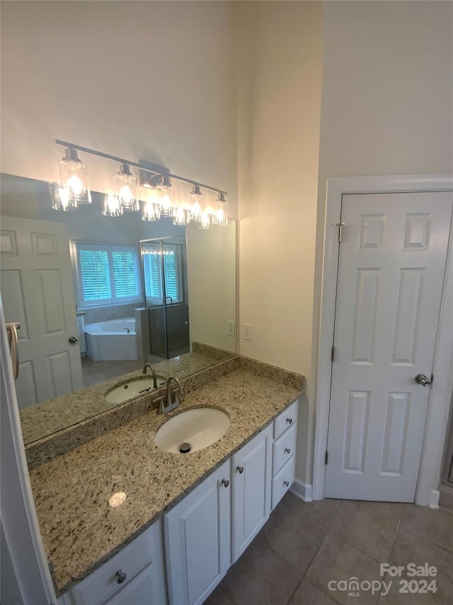 bathroom featuring vanity, a bath, and tile patterned flooring