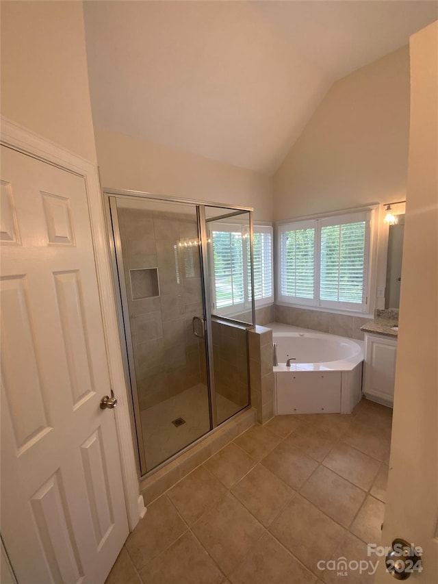 bathroom featuring tile patterned floors, lofted ceiling, separate shower and tub, and vanity