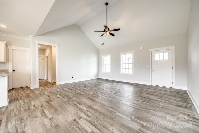 unfurnished living room featuring ceiling fan, high vaulted ceiling, and light wood-type flooring