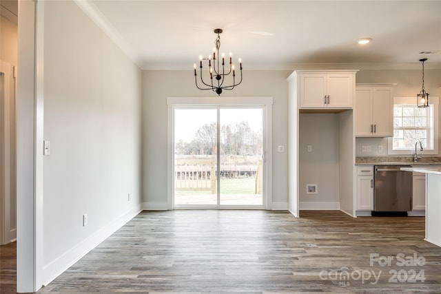 kitchen with stainless steel dishwasher, pendant lighting, white cabinetry, and a wealth of natural light