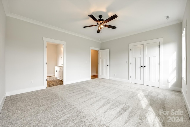 unfurnished bedroom with light carpet, a closet, ceiling fan, and ornamental molding