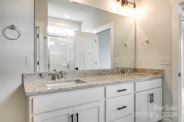 bathroom featuring vanity and a shower with shower door