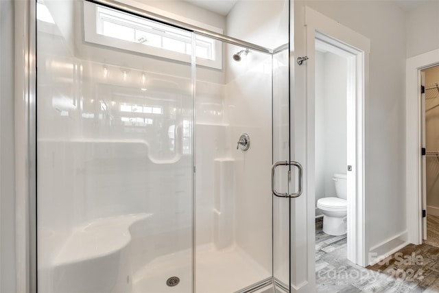 bathroom with walk in shower, hardwood / wood-style floors, and toilet