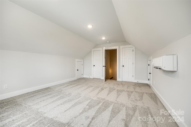 bonus room with light colored carpet and vaulted ceiling