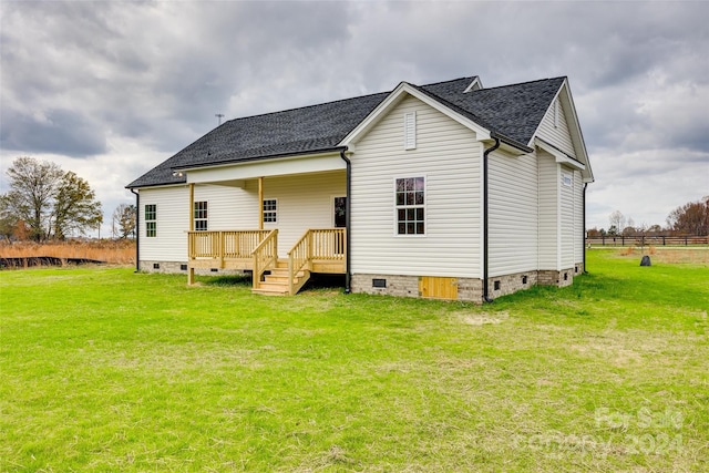 back of house with a lawn and a deck