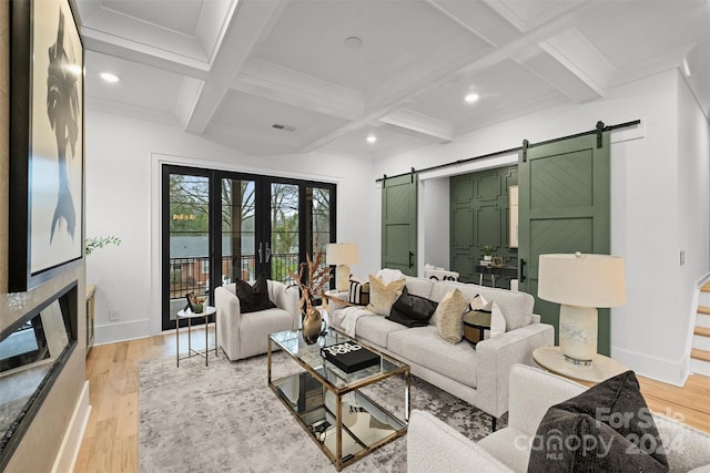 living room with light hardwood / wood-style floors, beam ceiling, a barn door, and coffered ceiling