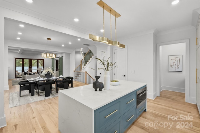 kitchen featuring beam ceiling, light hardwood / wood-style flooring, a center island, blue cabinetry, and decorative light fixtures