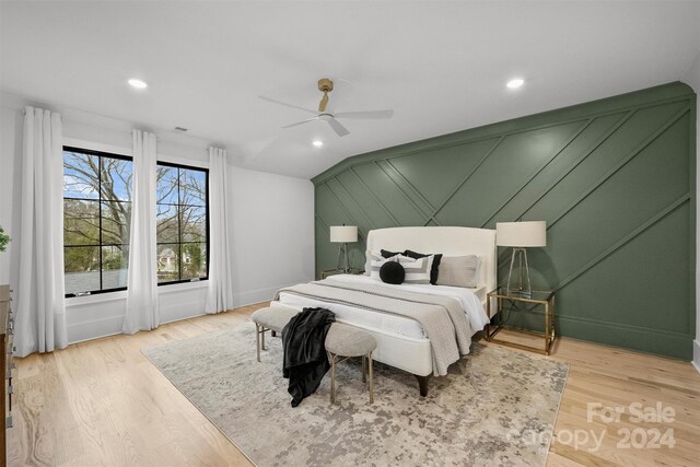 bedroom with ceiling fan, light hardwood / wood-style flooring, and vaulted ceiling