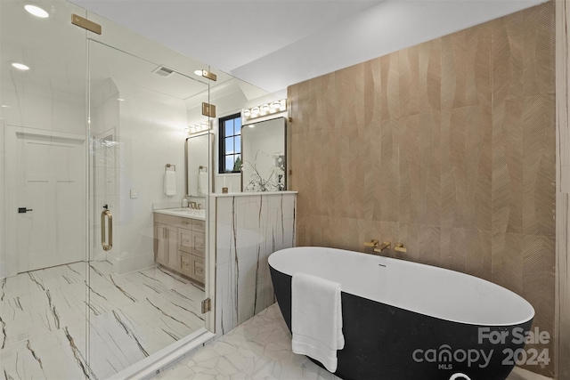 bathroom with vanity, tile patterned floors, separate shower and tub, and tile walls