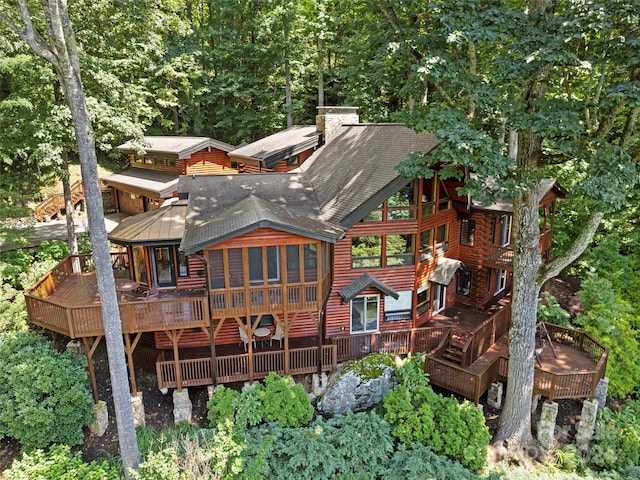 back of house featuring a wooden deck and a sunroom