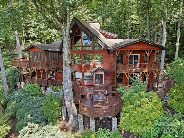 back of property featuring a wooden deck and a sunroom