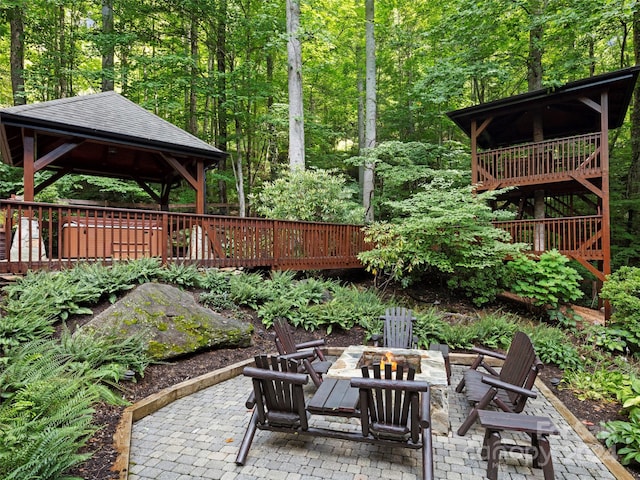 view of patio featuring a wooden deck, an outdoor fire pit, and a gazebo