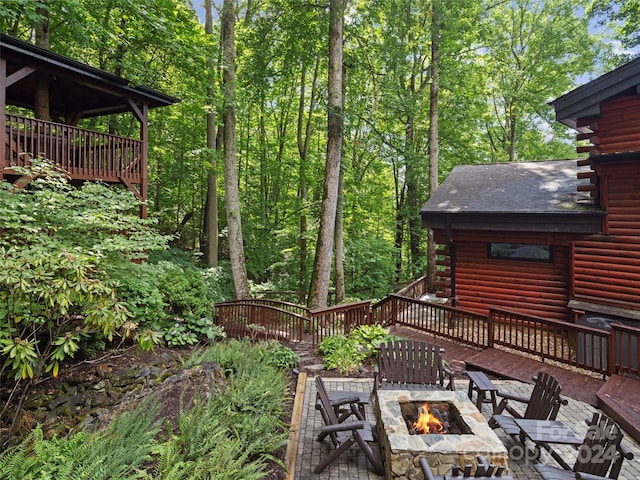 exterior space featuring a deck and an outdoor fire pit