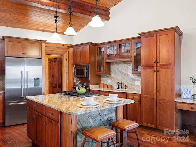 kitchen featuring decorative light fixtures, built in appliances, light stone countertops, wood ceiling, and a kitchen breakfast bar