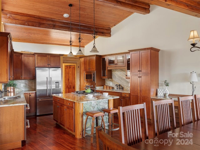 kitchen with hanging light fixtures, decorative backsplash, beamed ceiling, and built in appliances