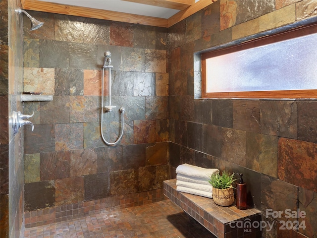 bathroom featuring tiled shower and crown molding