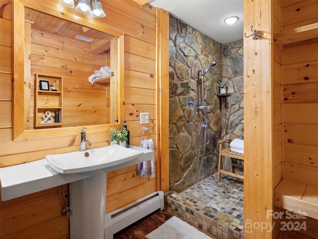 bathroom featuring a shower, a baseboard radiator, and wooden walls