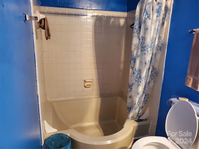 bathroom featuring shower / bath combo with shower curtain and toilet