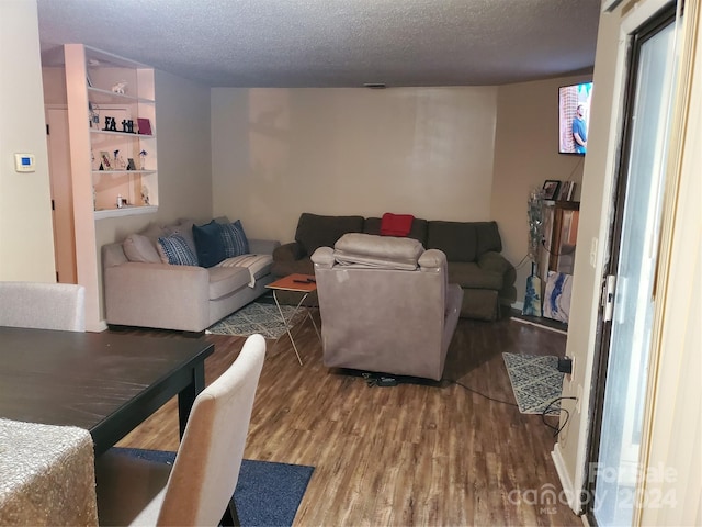 living room with hardwood / wood-style floors and a textured ceiling