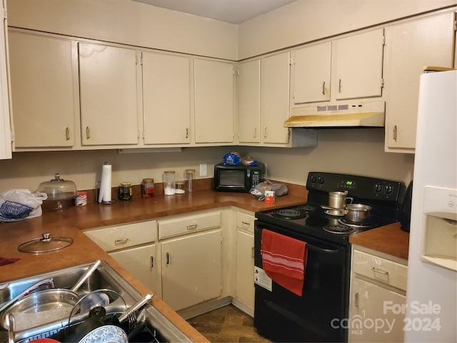 kitchen with light tile flooring, white cabinets, and black appliances