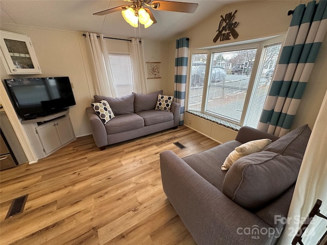 living room featuring lofted ceiling, ceiling fan, and light hardwood / wood-style flooring