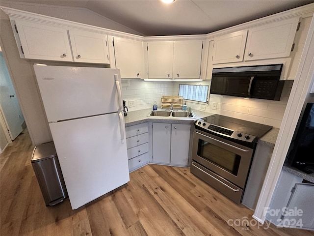 kitchen featuring white refrigerator, stainless steel electric range oven, light hardwood / wood-style flooring, white cabinets, and backsplash