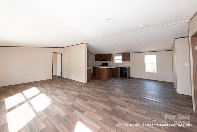 unfurnished living room featuring a textured ceiling, ornamental molding, and hardwood / wood-style flooring