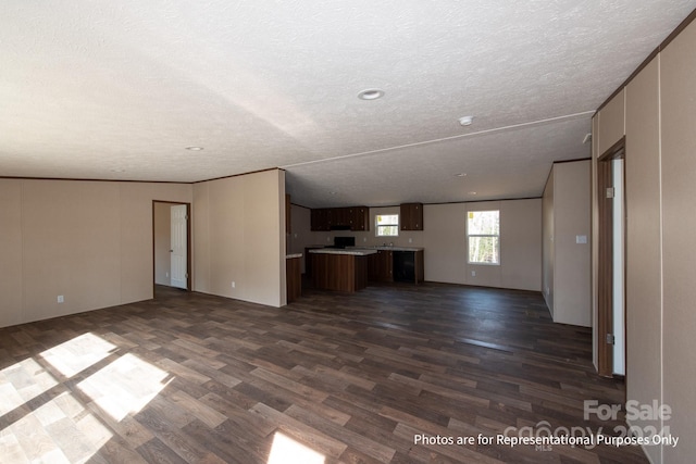 unfurnished living room featuring lofted ceiling, a textured ceiling, and dark hardwood / wood-style floors