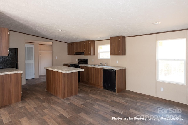 kitchen featuring a textured ceiling, dark hardwood / wood-style flooring, a healthy amount of sunlight, and black appliances