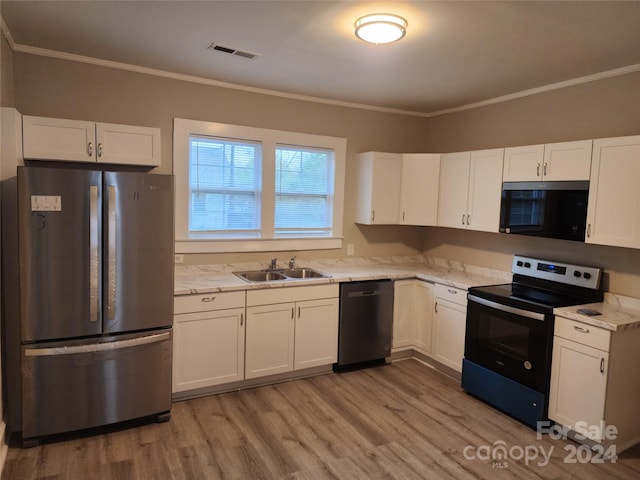 kitchen with white cabinets, crown molding, black appliances, hardwood / wood-style floors, and sink