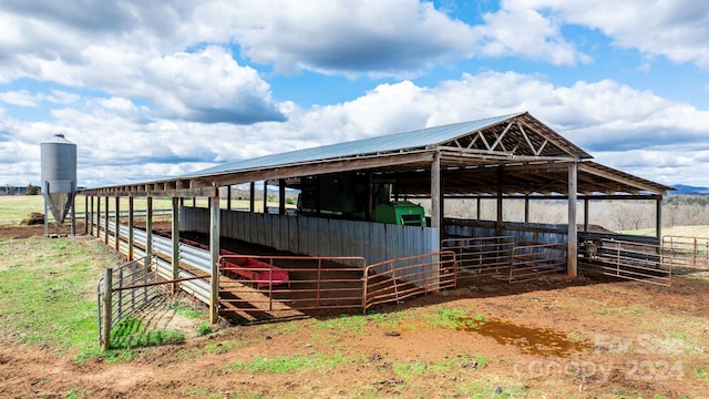 view of stable featuring an outdoor structure and a rural view