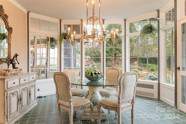 sunroom / solarium featuring radiator and an inviting chandelier