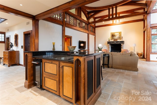 bar featuring beam ceiling and dark stone countertops