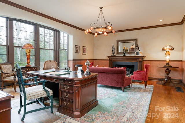 home office with an inviting chandelier, ornamental molding, and hardwood / wood-style flooring