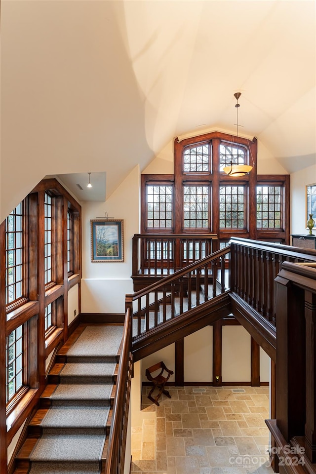 stairs with a healthy amount of sunlight and lofted ceiling