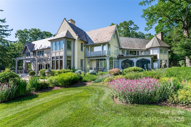 rear view of house with a yard and a pergola