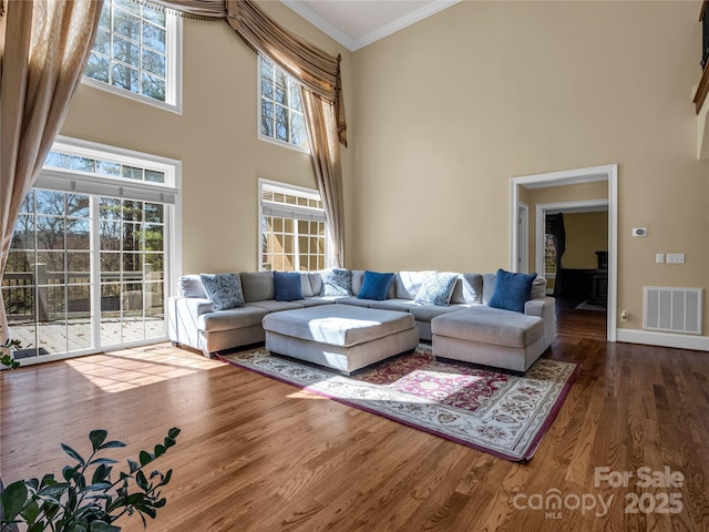 living room with crown molding, dark hardwood / wood-style floors, and a wealth of natural light