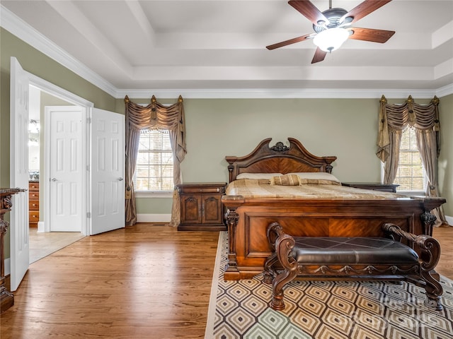 bedroom featuring a raised ceiling, ceiling fan, crown molding, and light hardwood / wood-style floors