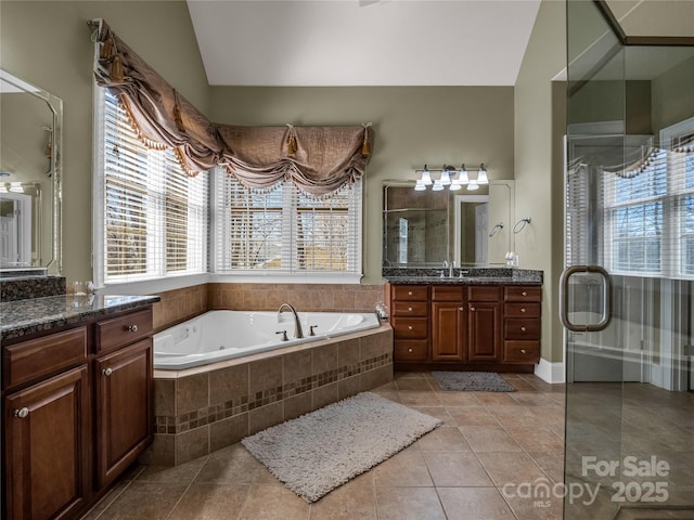 bathroom with tile patterned flooring, plus walk in shower, vaulted ceiling, and vanity