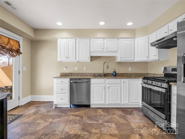 kitchen featuring dark stone countertops, sink, stainless steel appliances, and white cabinets