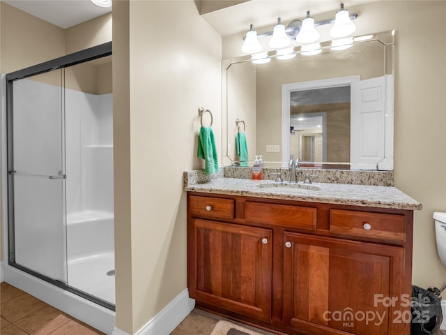 bathroom with tile patterned flooring, vanity, and walk in shower