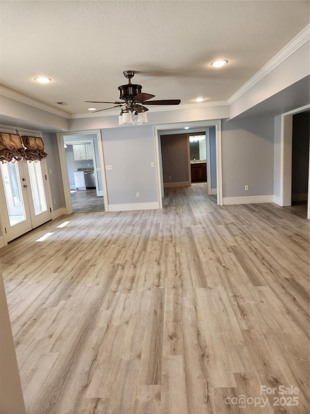 unfurnished living room featuring ornamental molding, a textured ceiling, light hardwood / wood-style floors, and french doors