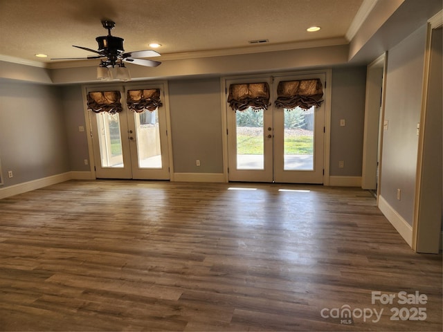 unfurnished room with crown molding, wood-type flooring, a textured ceiling, and french doors