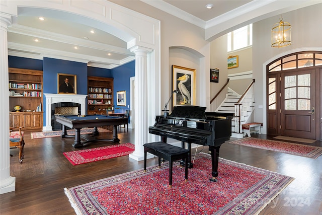 entrance foyer with crown molding, decorative columns, hardwood / wood-style floors, and a healthy amount of sunlight