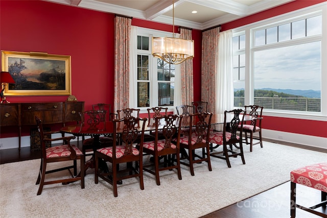 dining space with a mountain view, hardwood / wood-style flooring, a notable chandelier, and ornamental molding