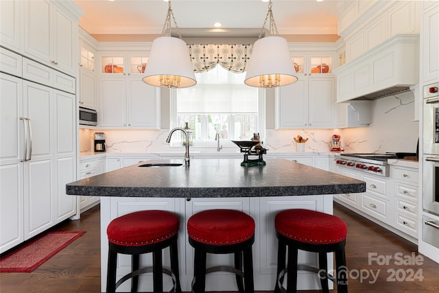 kitchen with sink, dark wood-type flooring, a kitchen island with sink, and backsplash